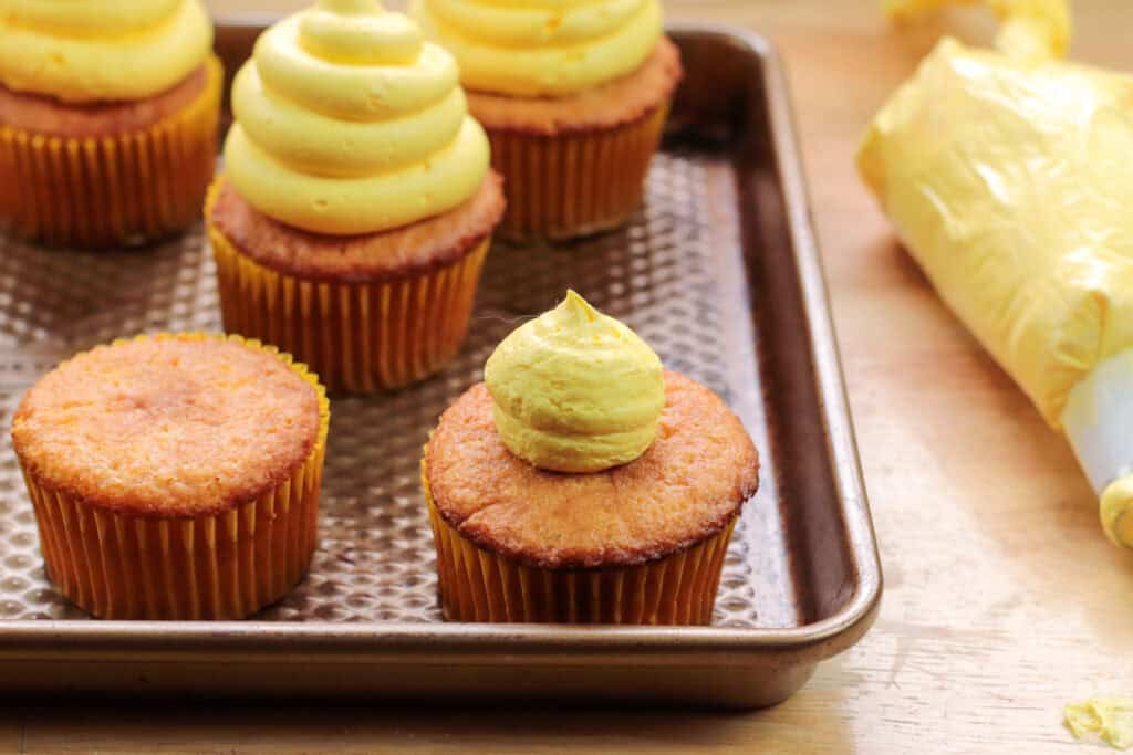 plain cupcakes topped with yellow frosting