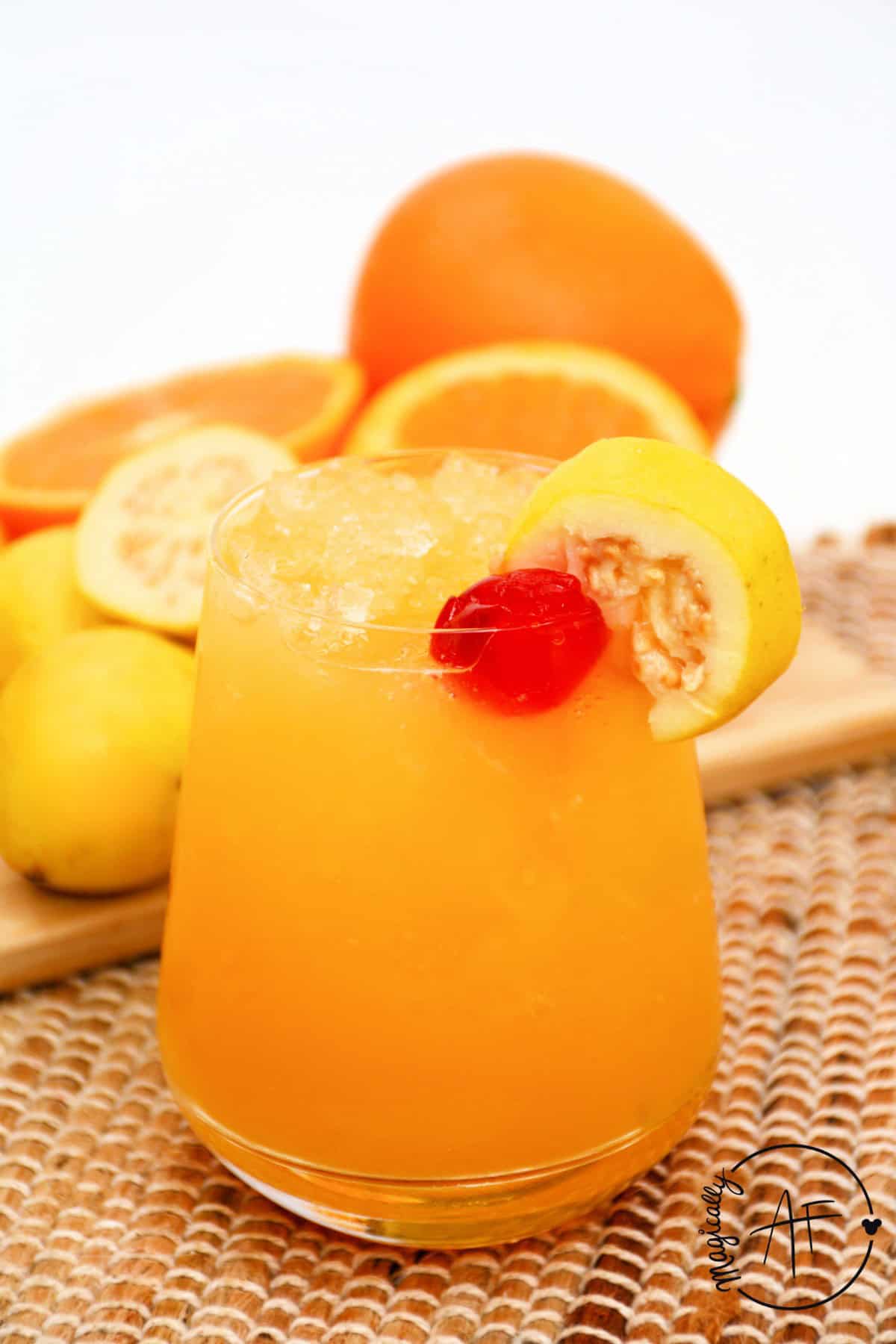 pog juice in a glass garnished with a cherry and slice of passion fruit